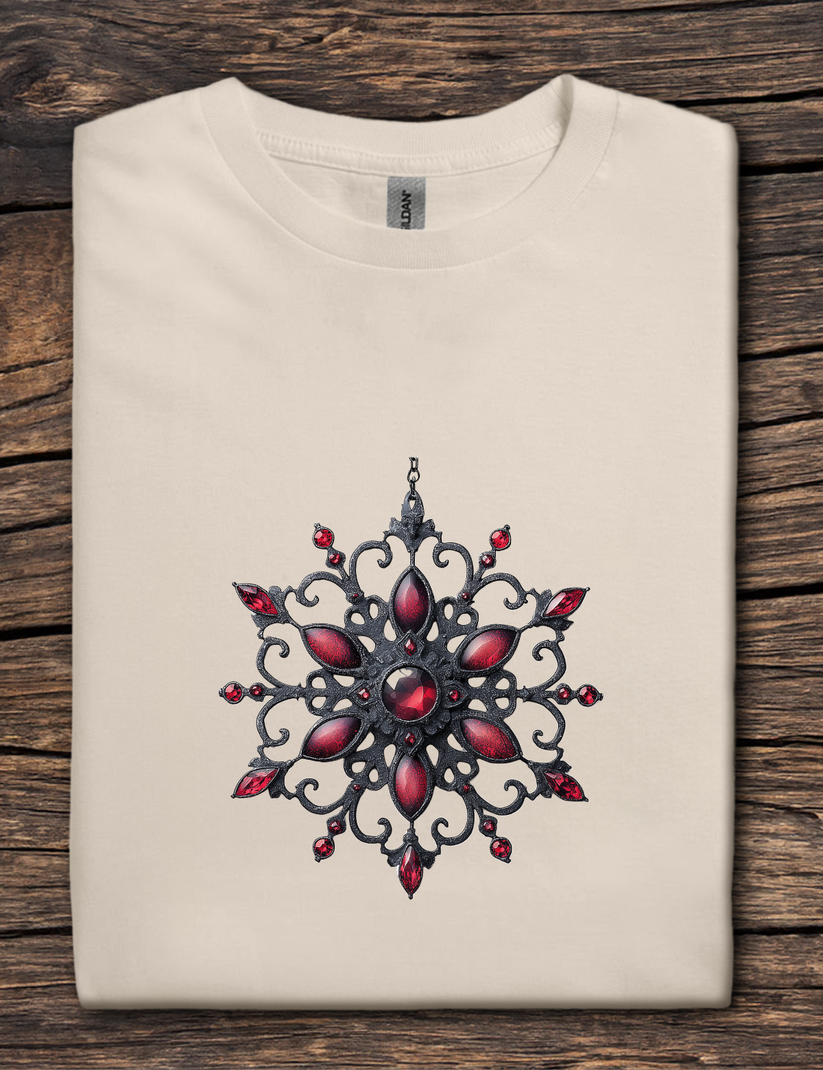 Beige t-shirt with a red and black decorative design on a wooden surface