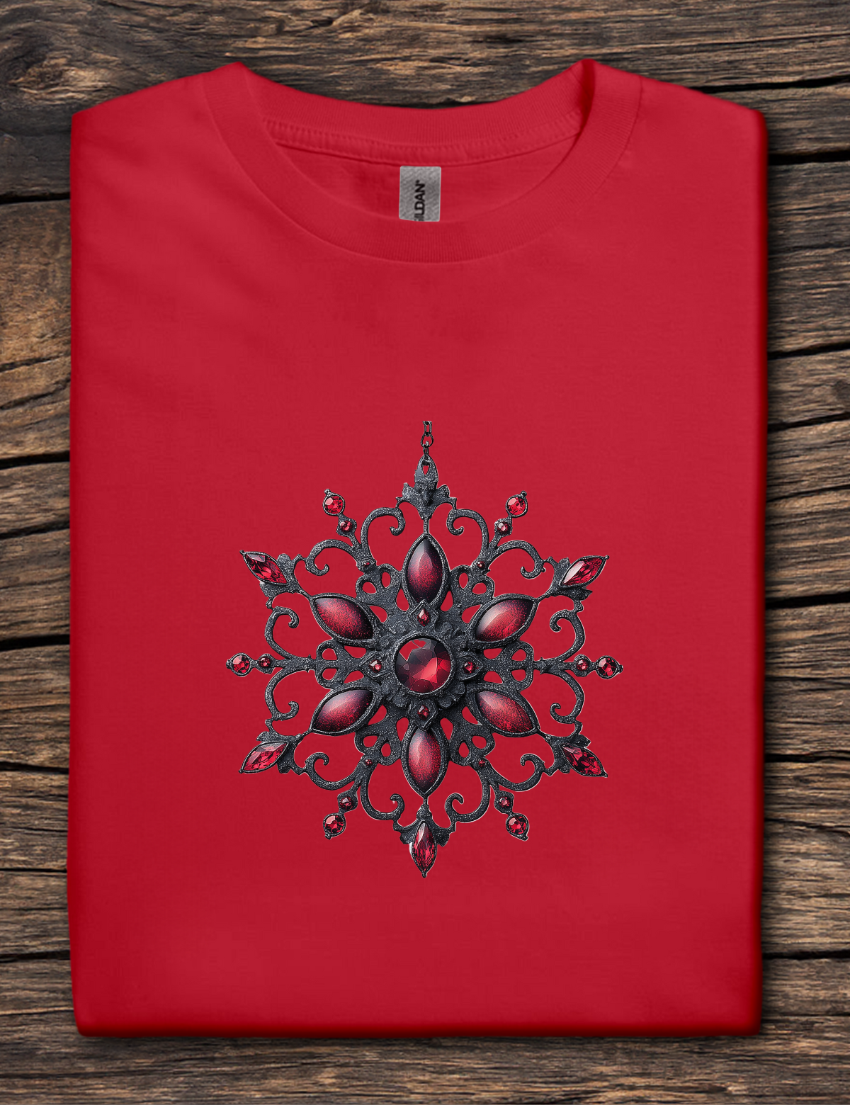 Red t-shirt with a black and red decorative design on a wooden surface