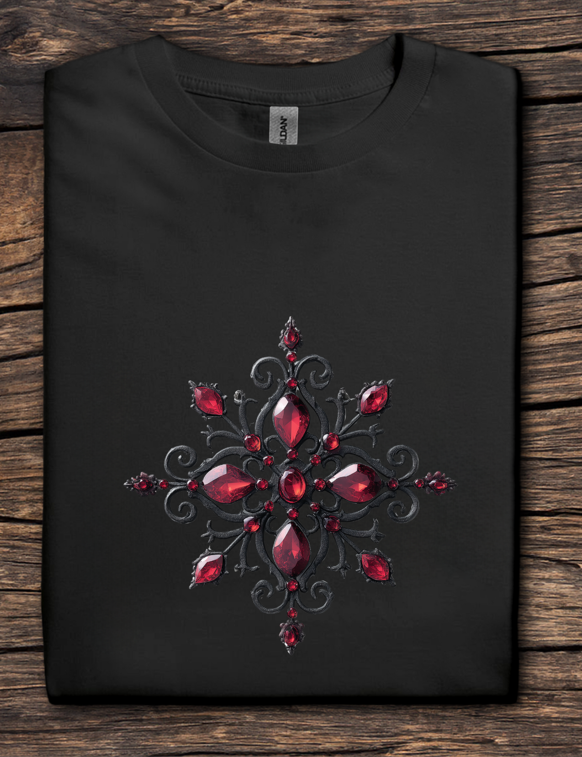 Black t-shirt with a red gemstone design on a wooden surface