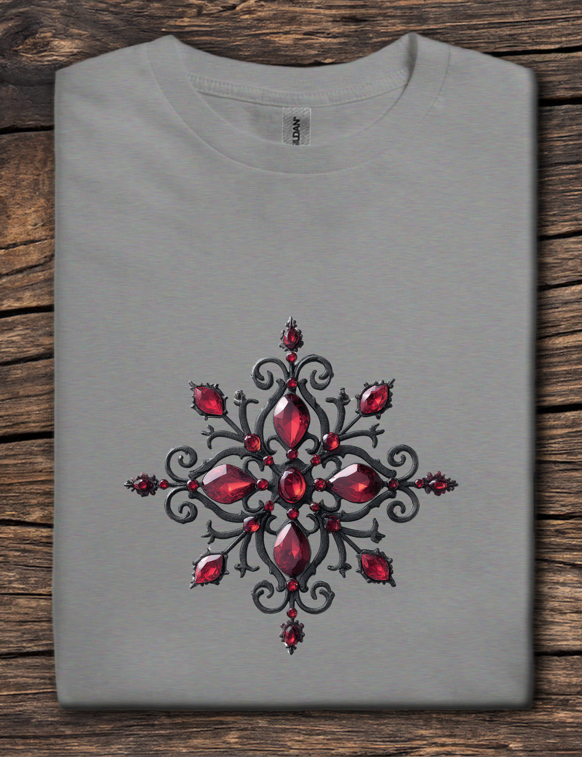 Gray t-shirt with a red and black decorative design on a wooden surface