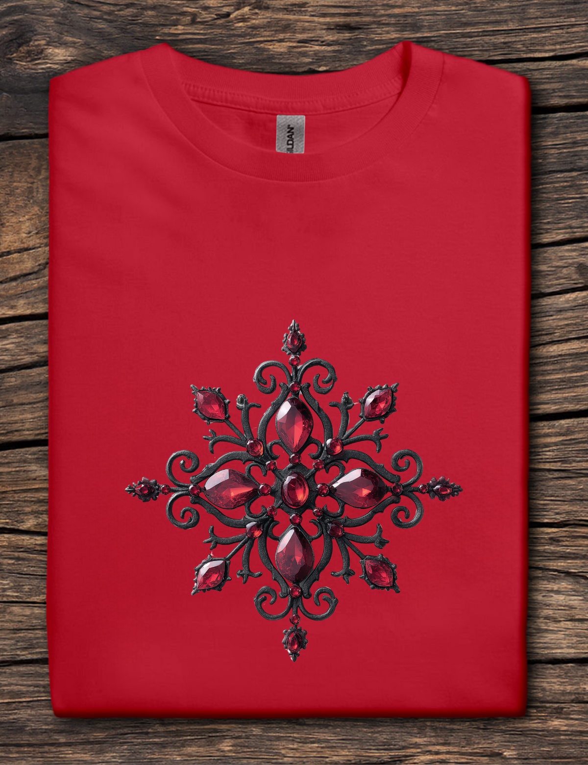 Red t-shirt with a black and red decorative design on a wooden surface