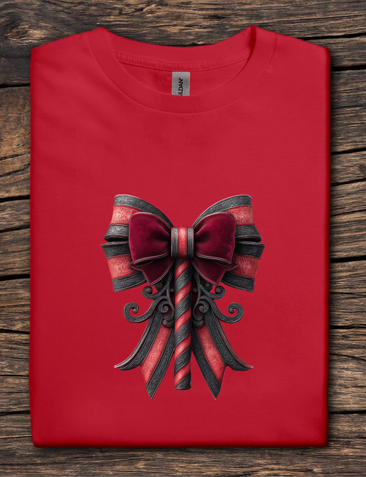 Red t-shirt with a black and red bow design on a wooden surface