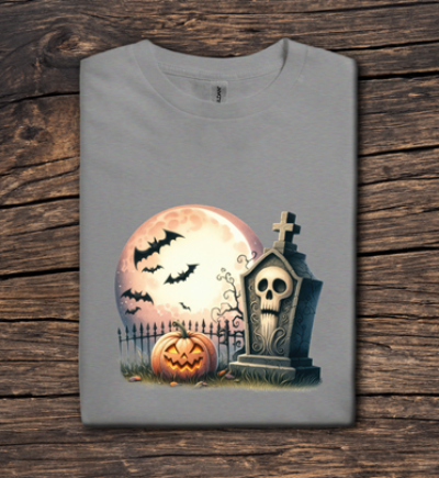 Gray t-shirt with Halloween design featuring a pumpkin, tombstone, and moon on a wooden surface