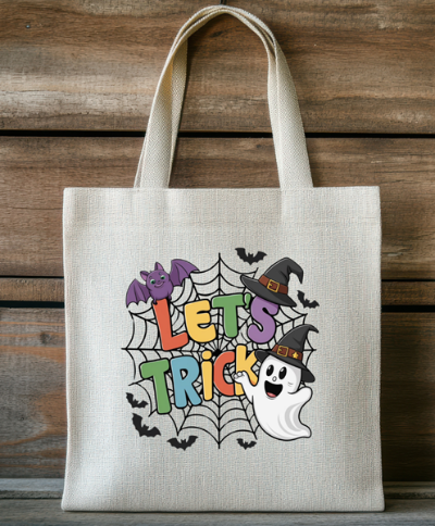 Tote bag with Halloween design featuring text 'LET'S TRICK' on a wooden background