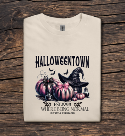 Beige t-shirt with 'Halloweentown' design on a wooden surface