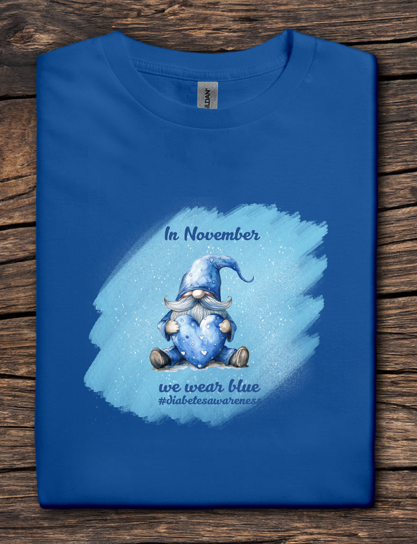 Blue t-shirt with a gnome graphic and text on a wooden surface