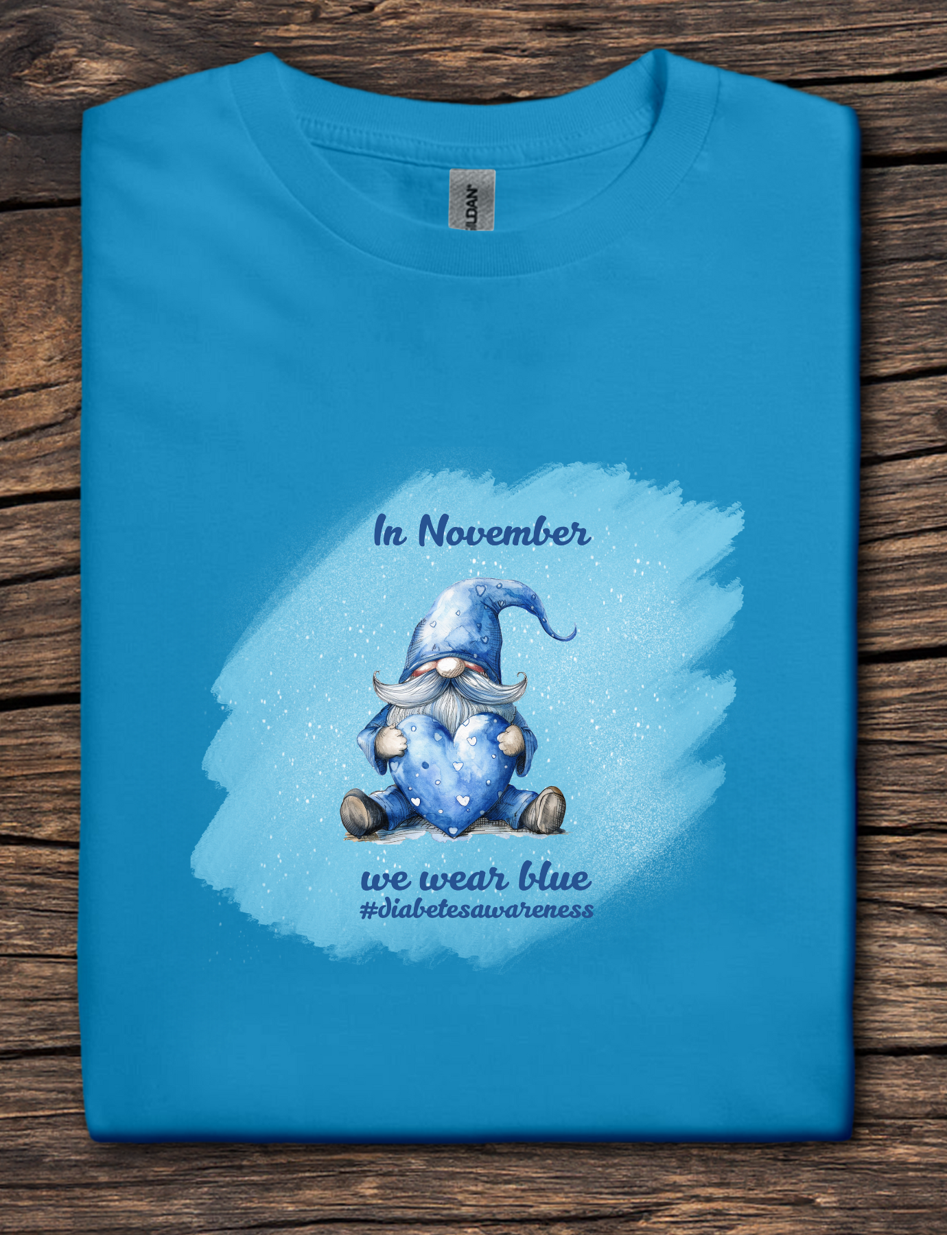Blue t-shirt with a gnome graphic and text on a wooden surface
