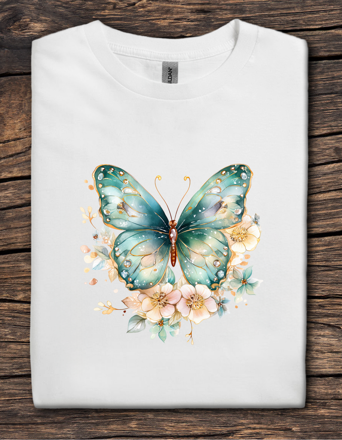 White t-shirt with a teal butterfly and floral design on a wooden surface