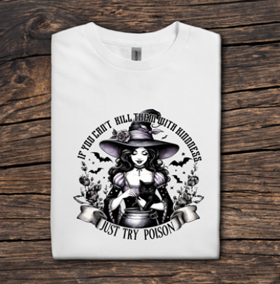 White t-shirt with black graphic design of a witch on a wooden surface