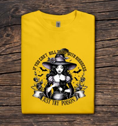 Yellow t-shirt with a witch graphic and text on a wooden surface