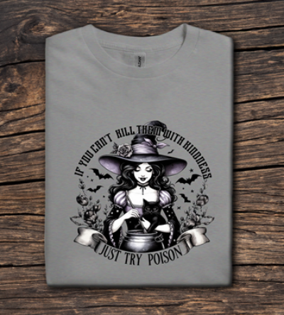 Gray t-shirt with a witch graphic and text on a wooden surface