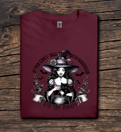 Maroon t-shirt with a witch graphic and text on a wooden surface