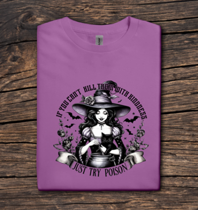 Purple t-shirt with a witch graphic and text on a wooden surface