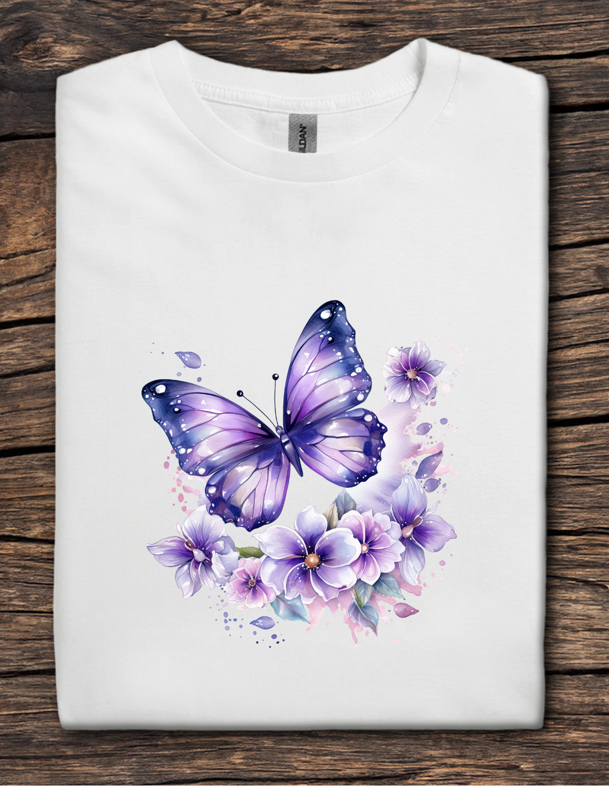 White t-shirt with a purple butterfly and floral design on a wooden surface