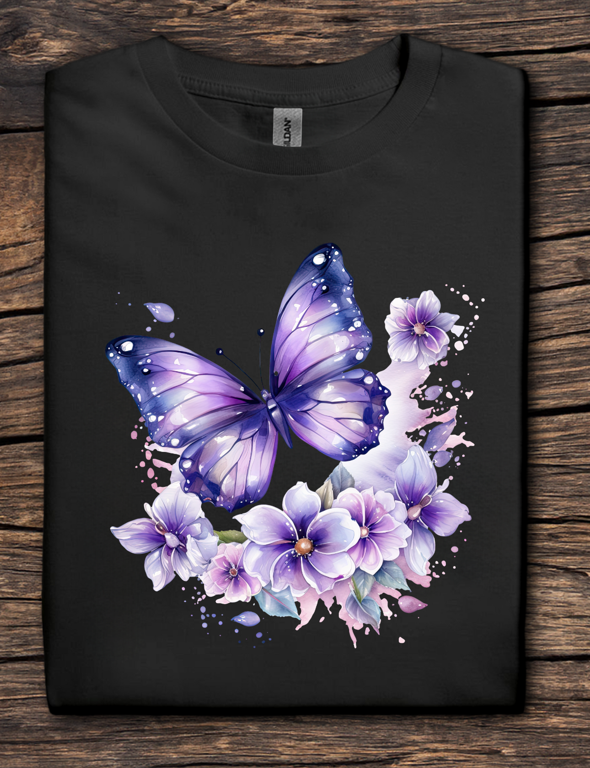 Black t-shirt with a purple butterfly and floral design on a wooden surface