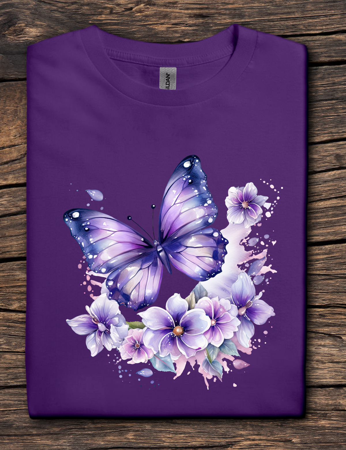 Purple t-shirt with a butterfly and floral design on a wooden surface