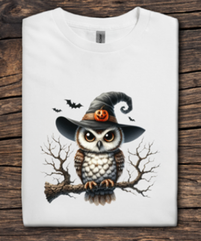 White t-shirt with a Halloween-themed owl design on a wooden surface