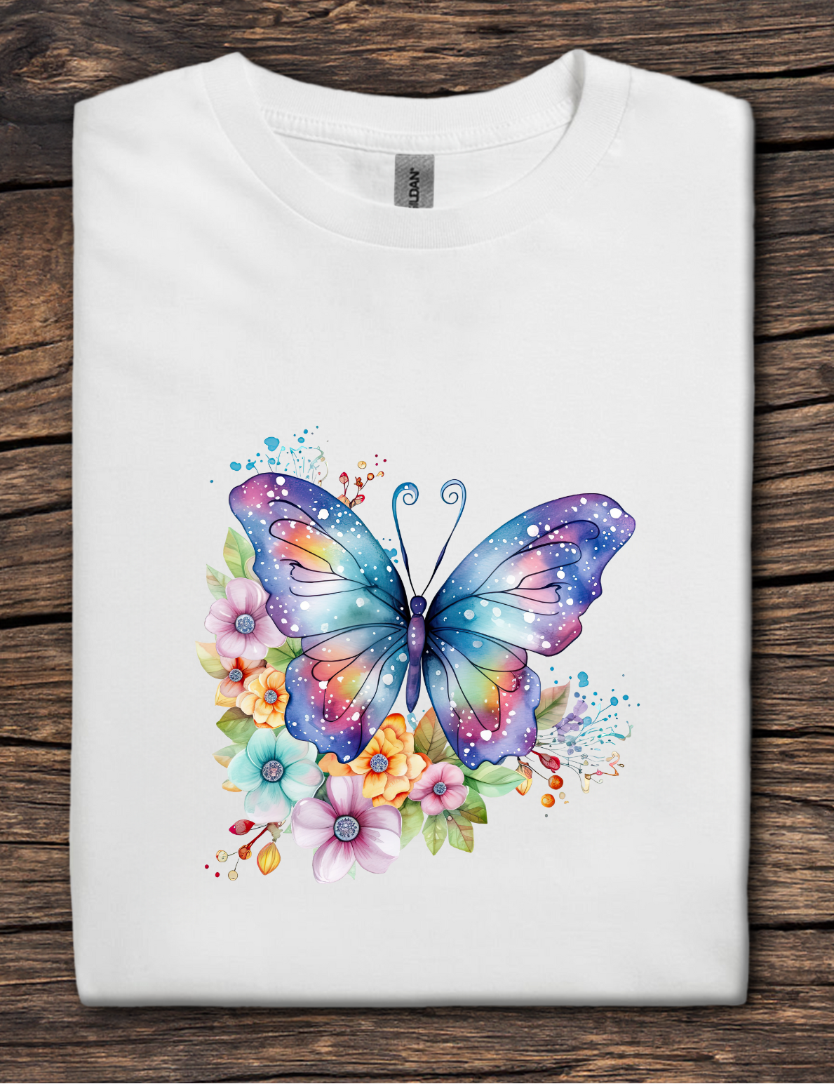 White t-shirt with a colorful butterfly and floral design on a wooden surface