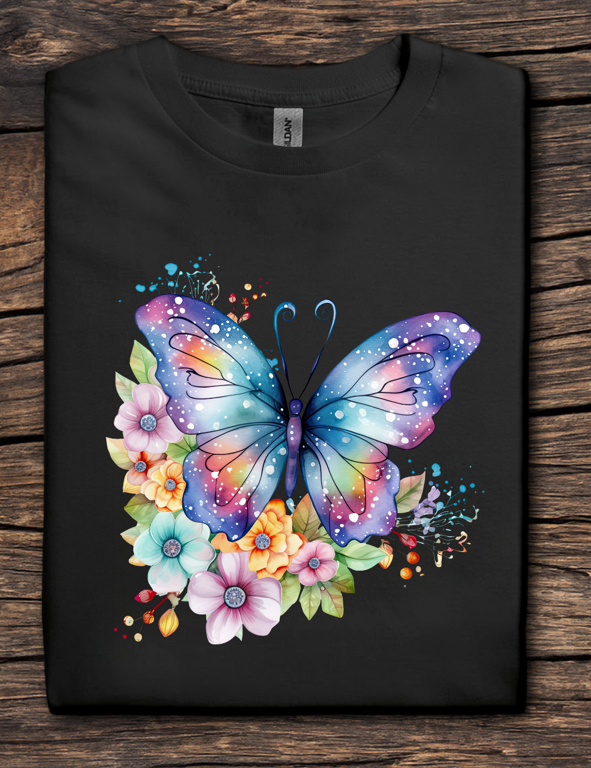 Black t-shirt with a colorful butterfly and floral design on a wooden surface