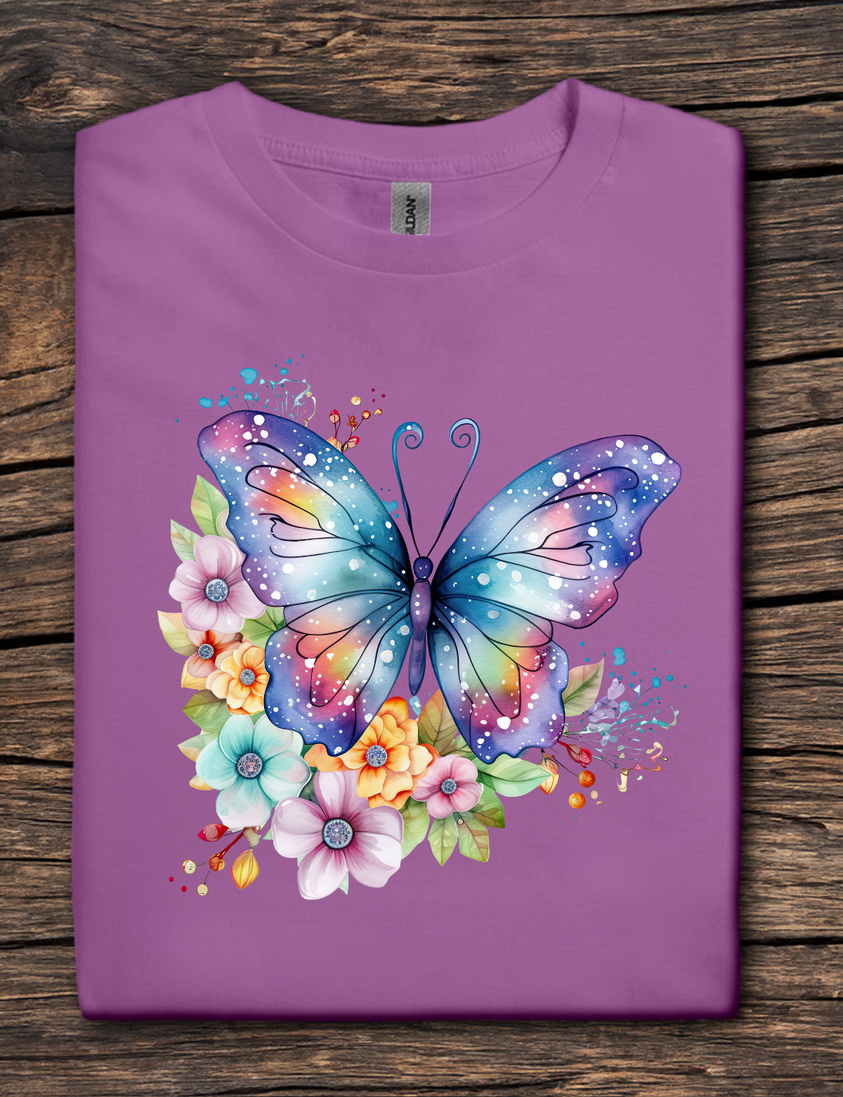 Purple t-shirt with a colorful butterfly and floral design on a wooden surface