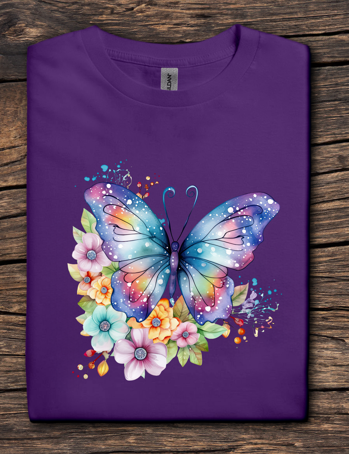 Purple t-shirt with a colorful butterfly and floral design on a wooden surface