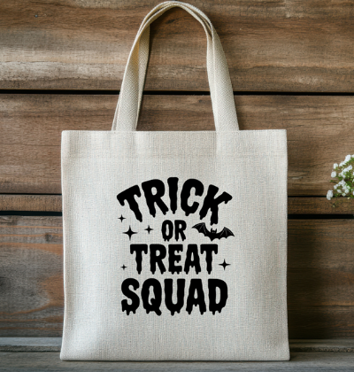 Tote bag with 'Trick or Treat Squad' text on a wooden background