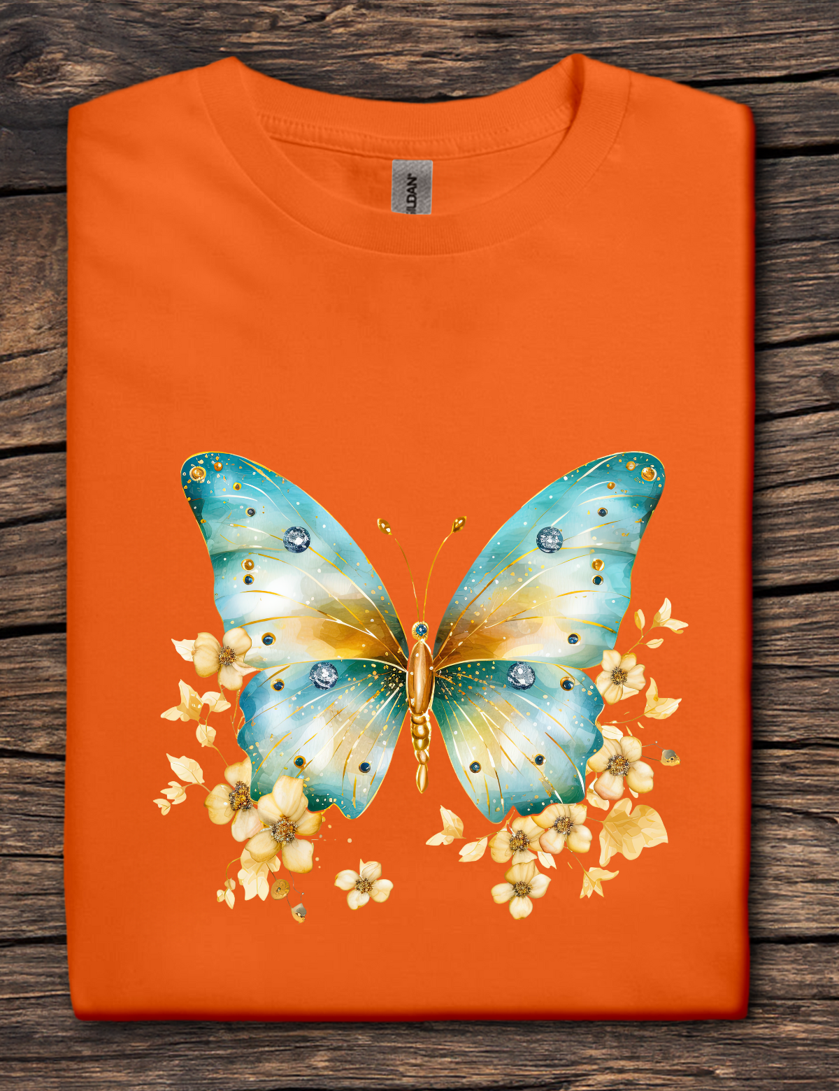Orange t-shirt with a blue butterfly design on a wooden surface