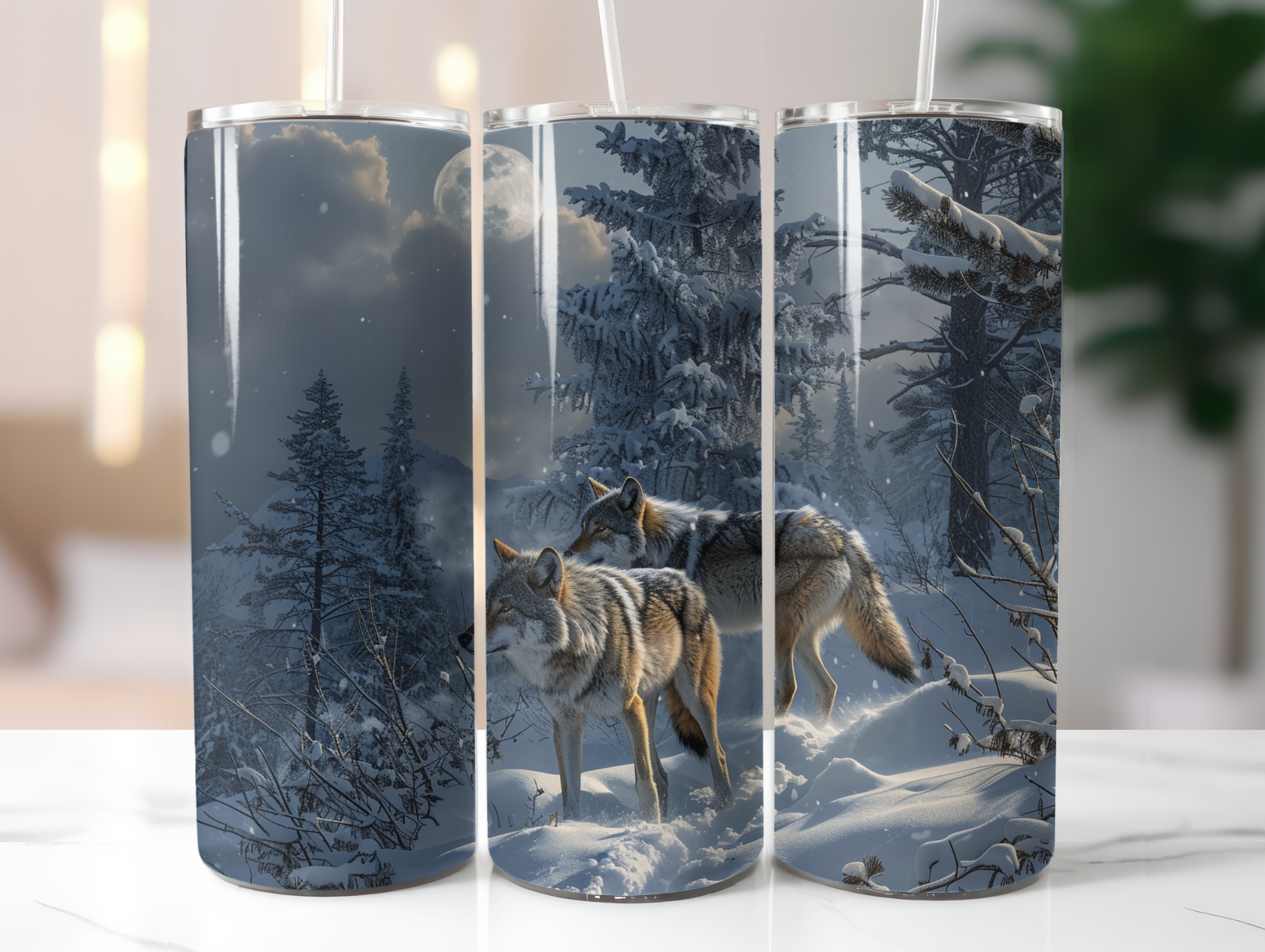 Three cylindrical tumblers with wolf and snowy forest design on a white surface.
